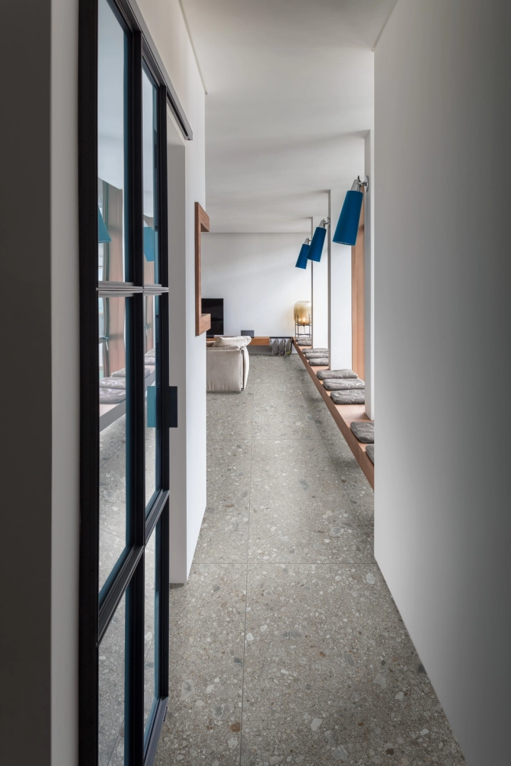 Wielkoformatowy gres Marazzi Mystone Ceppo DI Gre efekt terrazzo w salonie z kominkiem