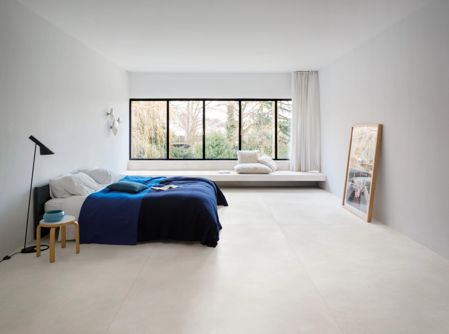 Płytki gresowe Marazzi Grande Concrete Look efekt beton w eleganckim salonie z dużymi przeszkleniami