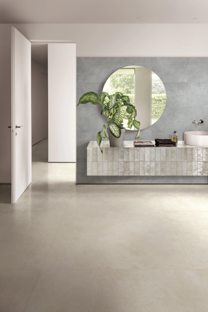 Wielkoformatowy gres Ragno Realstone Argent efekt beton w salonie z kominkiem