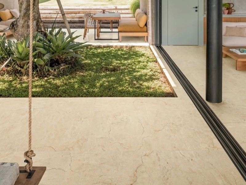 Płytki Marazzi Allmarble imitujące marmur w salonie z dużym przeszkleniem