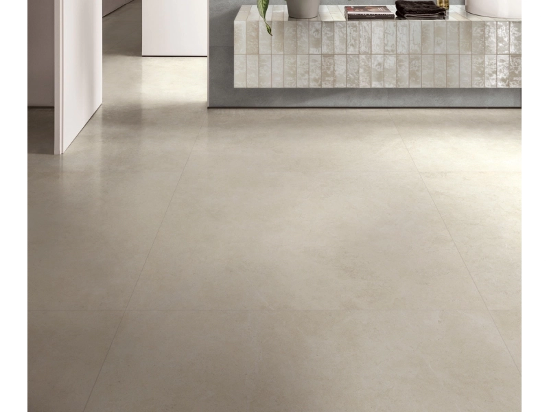 Wielkoformatowy gres Ragno Realstone Argent efekt beton w salonie z kominkiem