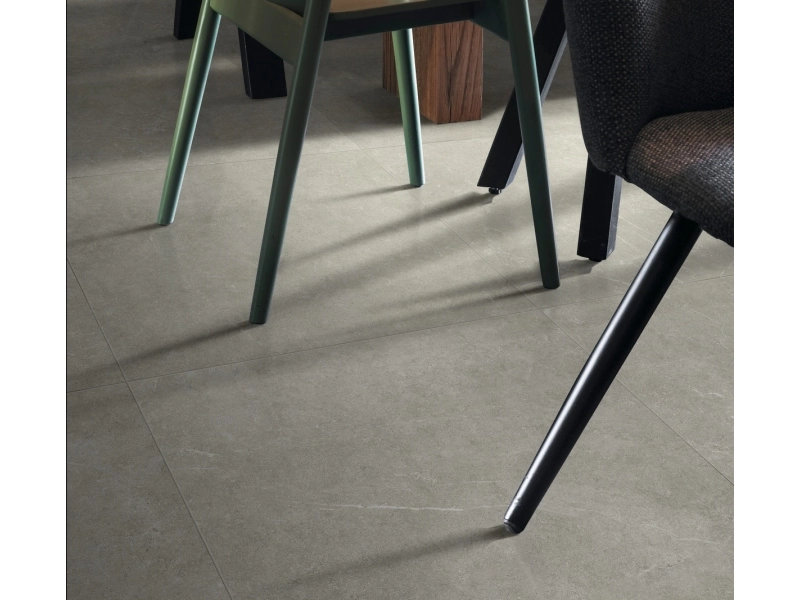 Płytki Ragno Realstone Argent imitujące beton w salonie z dużym przeszkleniem