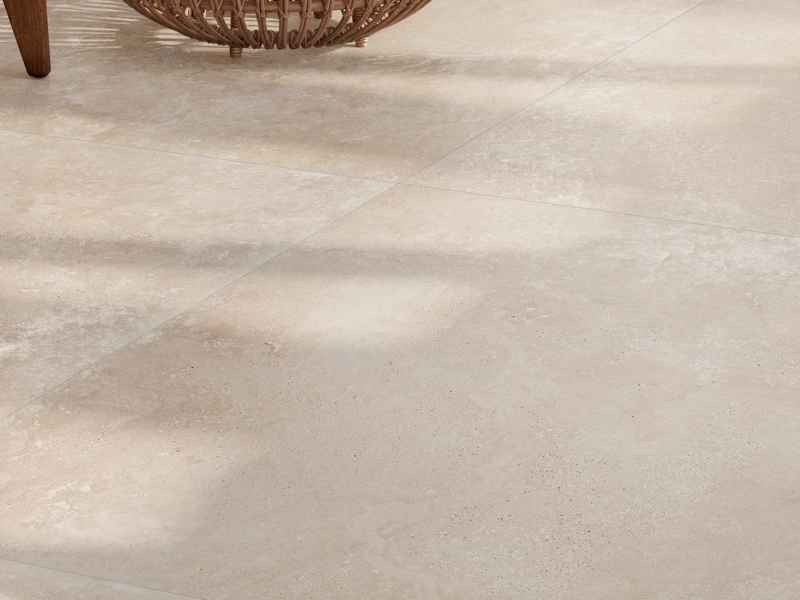 Gres Ragno Realstone Travertino efekt kamień w przestronnym salonie z oknami tarasowymi