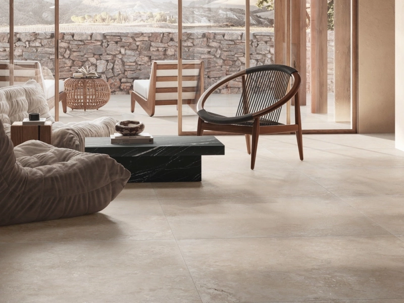Wielkoformatowy gres Ragno Realstone Travertino efekt kamień w salonie z kominkiem