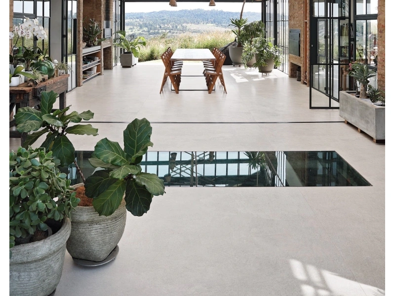 Wielkoformatowy gres Marazzi Grande Concrete Look efekt beton w salonie z widokiem na ogród